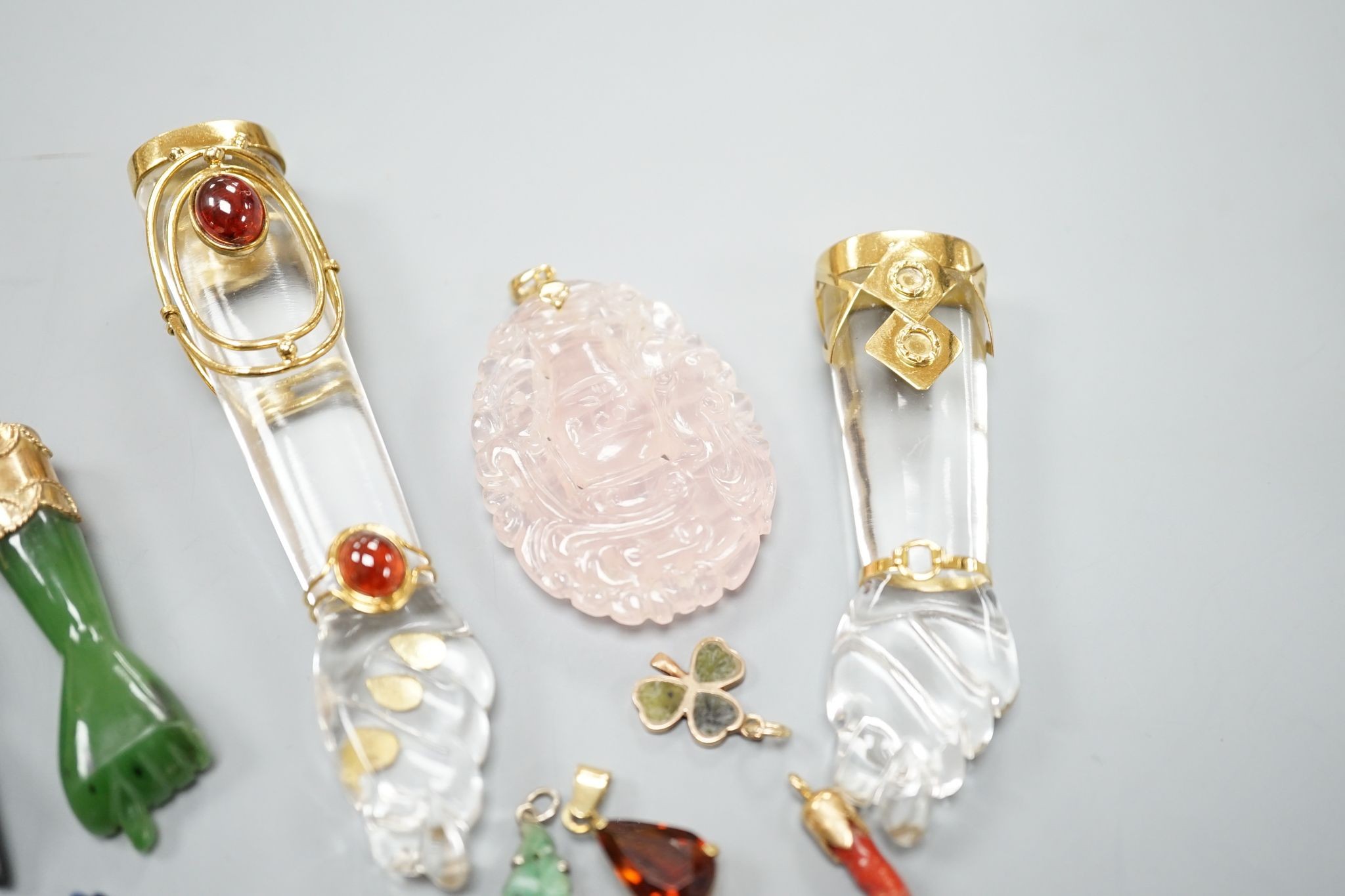 Seven assorted yellow metal or gilt metal mounted clasped hand charm or pendants, largest, 94mm, and seven other smaller charms/pendants including 14k and red enamel heart and an enamelled articulated fish.